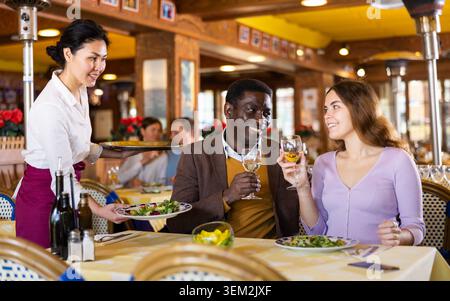 Une serveuse asiatique a apporté un plateau aux clients du restaurant Banque D'Images
