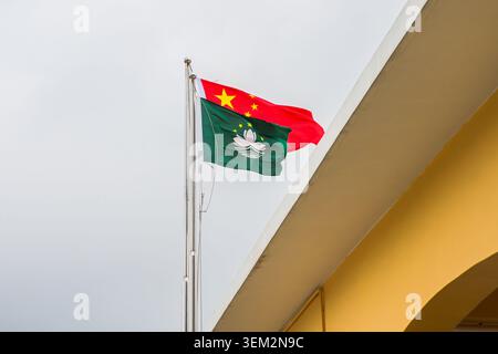 Drapeau national de la Chine et drapeau régional de Macao agitant sur le mât de drapeau près de l'historique bâtiment de la jetée de Coloane à Macao en Chine Banque D'Images