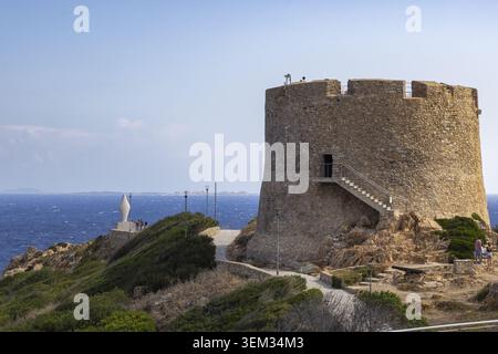 Vue sur la tour historique Longonsardo sur une falaise rocheuse surplombant la mer Méditerranée avec des gens marchant le long du sentier côtier à Santa Teresa G. Banque D'Images