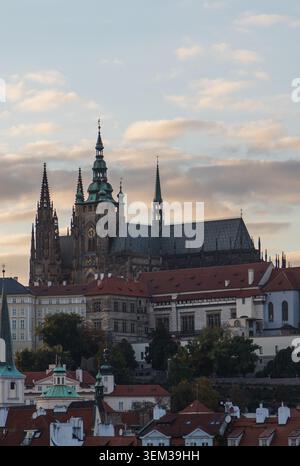 Vue de : Cathédrale Vitus avec ses flèches gothiques s'élevant au-dessus des toits historiques de tuiles rouges de la vieille ville sous un ciel nuageux doux à Prague, Pra Banque D'Images