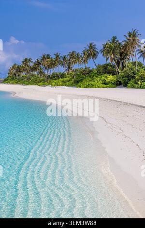 Plage tropicale de sable blanc incurvée rencontrant une mer turquoise claire avec une île de palmiers. Ciel bleu ensoleillé. Vacances d'été en famille, voyage, escapade océanique Banque D'Images