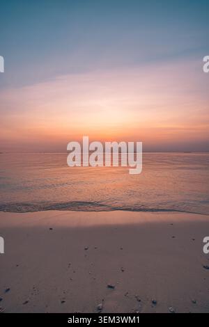 Couchant rose rêveur brillant sur l'océan tropical et la plage tranquille à la douceur dorée du crépuscule. Rivage paisible de paysage estival. Voyage de vacances au paradis, lune de miel, romance Banque D'Images