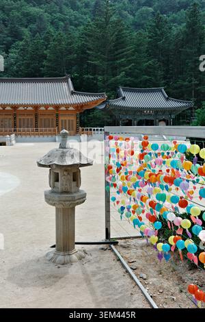 Lanterne en pierre et lanternes en papier bouddhiste colorées avec des étiquettes de prière dans la cour du temple Woljeongsa, parc national d'Odaesan, province de Gangwon Banque D'Images