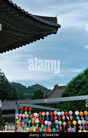 Lanternes en papier bouddhistes colorées avec des étiquettes de prière suspendues sous l'avant-toit ornée du temple dancheong au temple Woljeongsa, Odaesan, province de Gangwon Banque D'Images