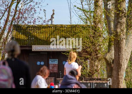 Vue extérieure d'un bâtiment de toilettes publiques en bois rustique avec un toit couvert de mousse dans un centre naturel en plein air. Burscough. Banque D'Images
