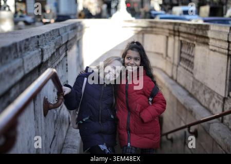 Deux amies joyeuses souriant dans les escaliers de la ville Banque D'Images