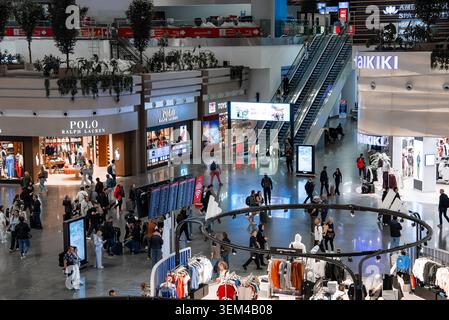 Voyageurs à Istanbul Airport départs hall avec magasins et planches Banque D'Images