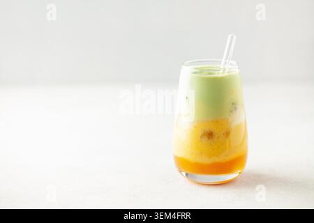 Latte matcha à la mangue glacée en verre sur la table Banque D'Images