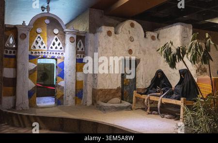 Diorama dans le Musée nubien, Assouan, Egypte de deux femmes nubiennes assis à l'extérieur de leur maison traditionnellement décorée, faisant des paniers. Banque D'Images
