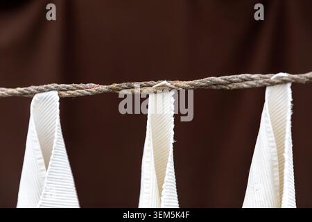 Un gros plan de vêtements blancs accrochés à une corde traditionnelle pour sécher dans la blanchisserie publique historique de Dhobi Khana à Kochi ; Kerala, Inde Banque D'Images