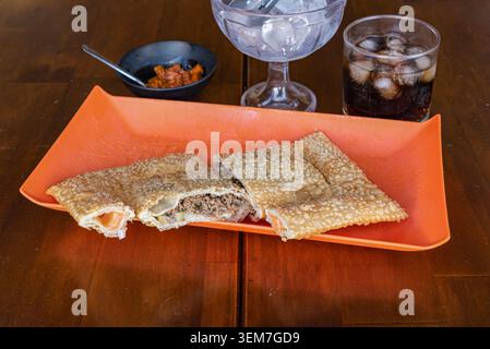 Pâte pastel croustillante et feuilletée fourrée de viande hachée salée, isolée sur bois. Un éclairage lumineux et diffus accentue les textures. Idéal pour les blogs alimentaires ou R Banque D'Images