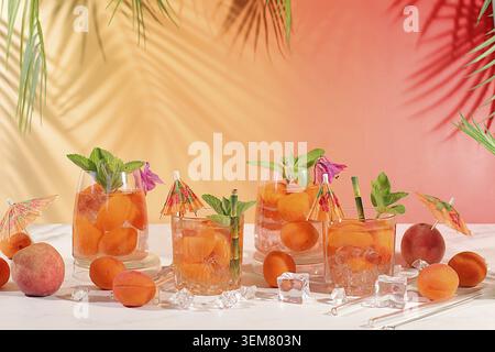 Thé de pêche glacé ou cocktail à la menthe et aux abricots, recette rafraîchissante de boisson estivale. Deux verres avec limonade aux fruits de pêche sur une table lumineuse, régime détox Banque D'Images