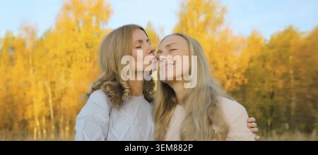 Portrait de fille adulte heureuse embrassant et embrassant sa mère mature souriante deux femmes dans le parc d'automne Banque D'Images