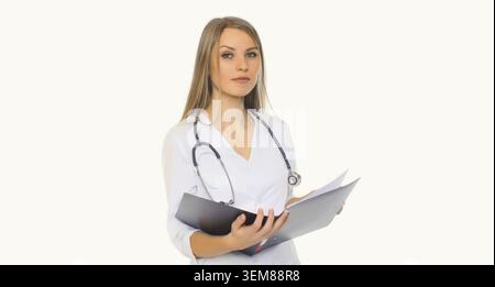 Portrait de jeune femme médecin avec stéthoscope et dossier de documents posant sur fond blanc de studio Banque D'Images