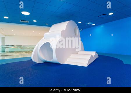États-Unis, Fort Lauderdale, FL - 18 mai 2026 : sculpture de nuage blanc avec des marches et des stands de tunnel sur un sol bleu à l'intérieur de l'aire de jeux de l'aéroport de Fort Lauderdale Banque D'Images