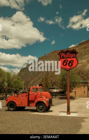 Camion vintage affiché à côté d'un panneau Phillips 66 à Helper, Utah, États-Unis, célébrant le patrimoine routier de la ville. Banque D'Images