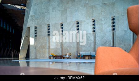 Le salon du hall de l'hôtel de luxe moderne est situé face à un mur de pierre massif Banque D'Images