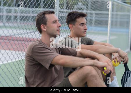 Personnes actives et diverses jouant au Pickleball sur un court extérieur Banque D'Images