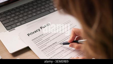 Femme lisant et signant des documents importants sur la politique de confidentialité à l'intérieur. Banque D'Images