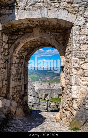 Le passage en pierre historique à l'intérieur du château de Spis offre une vue sur la cour du château, la campagne environnante et les sommets enneigés des Hautes Tatras Banque D'Images