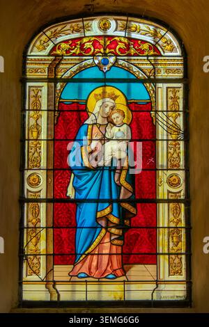 Hautvillers, France, 25 mai 2026. Un beau vitrail antique représentant la Vierge Marie tenant l'enfant Jésus Christ, situé à l'intérieur Banque D'Images