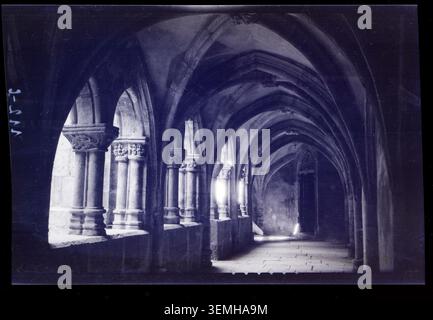 La galerie sud du cloître de l'abbaye de Montbenoît à Montbenoît, Doubs, France, est photographiée en 1928 par Marcel Maillard, illustrant les arcades monastiques et les détails architecturaux de l'abbaye. Banque D'Images