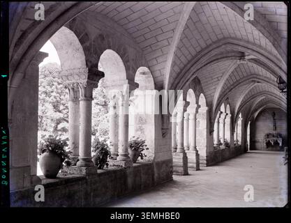 La galerie sud du cloître de l'abbaye notre-Dame de Bonnevaux à Marçay (Vienne, France) est photographiée par Marcel Maillard en 1953, retraçant l'architecture abbatiale et la disposition de ses espaces du cloître. Banque D'Images