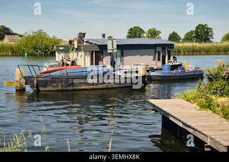 Une péniche moderne panneaux solaires sur son toit, symbolisant un mode de vie durable et des pratiques respectueuses de l'environnement, est amarrée le long d'un canal tranquille à Nederhorst Banque D'Images