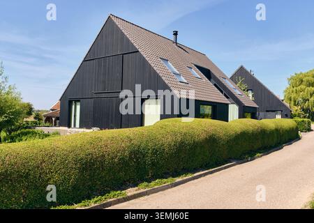 Nederhorst Den Berg, pays-Bas - 24 mai 2026 : architecture moderne de maison en bois noir mettant en valeur le design contemporain et la vie durable avec un s Banque D'Images