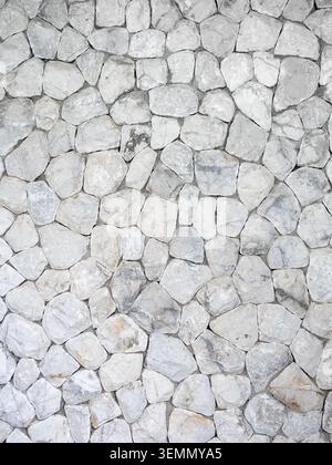 Texture murale en pierre blanche naturelle avec motif rocheux irrégulier et détail de surface rustique. Fond de pierre décoratif pour l'architecture, design extérieur, Banque D'Images