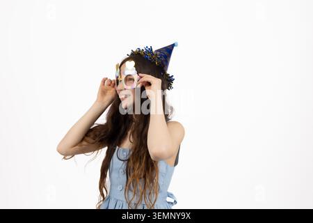 Jeune femme appliquant des patchs cosmétiques sous ses yeux en studio Banque D'Images
