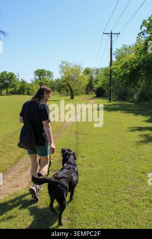Femme marchant dans le parc avec son chien Banque D'Images