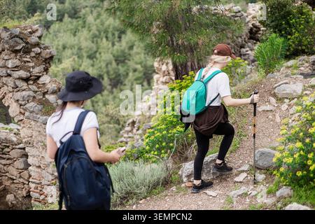 Deux jeunes amies marchant sur un sentier de montagne rocheux Banque D'Images