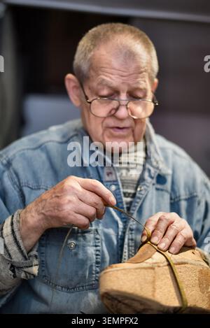 Artisan senior coudre à la main une chaussure en cuir Banque D'Images
