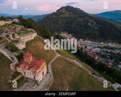 Vue aérienne du château de Berat avec l'église de la Sainte Trinité, les anciennes fortifications en pierre et les collines environnantes au crépuscule à Berat, Qarku i berat Banque D'Images