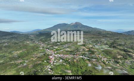 Vue aérienne du village d'Alahan Panjang et des champs agricoles avec le mont Talang en arrière-plan sous un ciel dégagé à Lembah Gumanti, Sumatra Ouest, I. Banque D'Images