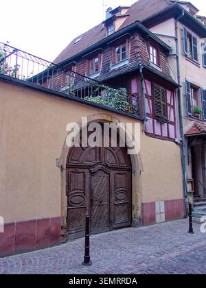 Colmar, France. 14 octobre 2006 : porte en bois voûtée et étage supérieur à colombages sur un bâtiment historique de la vieille ville de Colmar. Banque D'Images