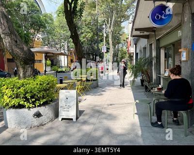 Un petit café sur le trottoir dans une rue verdoyante à Roma sur, Mexico, Mexique. Banque D'Images