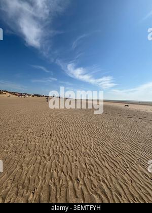 Large plage de sable à Camber Sands près de Rye, East Sussex, Angleterre, avec des spectateurs, un chien et des nuages spectaculaires sur les coas anglais Banque D'Images