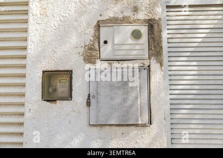 Compteur résidentiel et armoire de service électrique montés sur le mur extérieur de la maison méditerranéenne Banque D'Images
