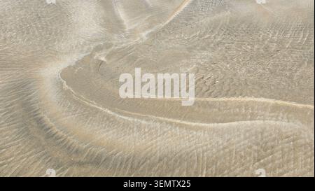 Vue de dessus des ondulations naturelles et des textures dans le sable de plage après la marée basse Banque D'Images