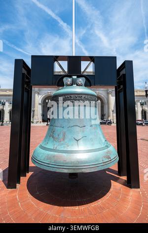American Legion Freedom Bell Cadre en acier Union Station Washington DC | WASHINGTON — Maintenue dans un cadre de support en acier noir, la cloche Freedom Bell de l’American Legion est suspendue sur la Columbus Plaza face à la façade en arc de la gare Union Station à Washington, D.C. Coulée le 17 janvier 1975 dans la fonderie N. V. Petit & Fritsen aux Pays-Bas, cette cloche en bronze pesant environ 16 830 livres (7 634 kg) a parcouru les 48 États contigus à bord de l’American Freedom Train avant que le Congrès n’autorise son installation permanente ici en 1981. Banque D'Images