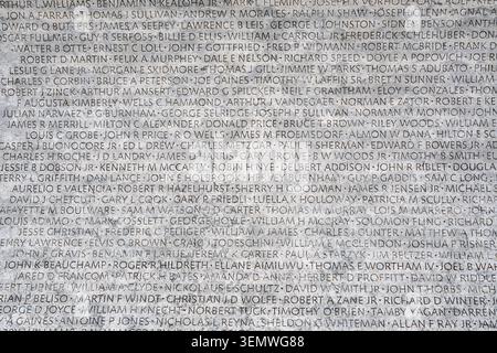 Mémorial national des agents de la loi, noms gravés sur un mur de marbre à Washington DC | WASHINGTON D.C., États-Unis — Des rangées de noms gravés recouvrent un mur en calcaire au Mémorial national des agents de la loi sur la place Judiciary, rendant hommage aux agents tués dans l'exercice de leurs fonctions. Inauguré le 15 octobre 1991, le mémorial compte deux murs incurvés qui ont inscrit 12 561 noms lors de l'ouverture ; en 2026, ce nombre avait augmenté à 24 775, avec des ajouts gravés chaque printemps pour la Semaine nationale de la police. Banque D'Images