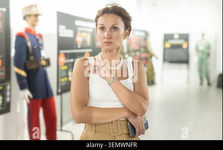 Femme d'âge moyen regardant des expositions dans le musée militaire Banque D'Images