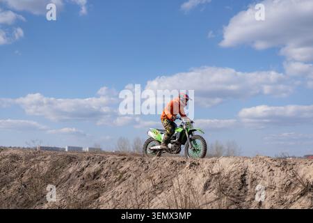 Kharkov Ukraine en mars 2021, le pilote pratique le motocross sur une moto enduro sur une piste hors route à Kharkov, en Ukraine. La scène montre le cavalier naviguant dans des sentiers de terre sous un ciel dégagé. Banque D'Images
