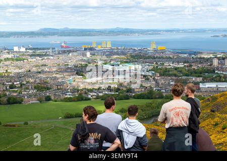 Touristes regardant sur Édimbourg depuis le sommet d'Arthurs Seat, Holyrood Park, Édimbourg, Écosse Banque D'Images