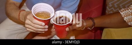 Amis adultes dégustant des boissons du jour de l'indépendance à la fête de la maison Banque D'Images