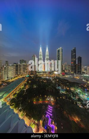 Vue nocturne ultra-large sur les tours jumelles Petronas illuminées et les gratte-ciel dynamiques de la ville sur le parc KLCC à Kuala Lumpur, Malaisie Banque D'Images