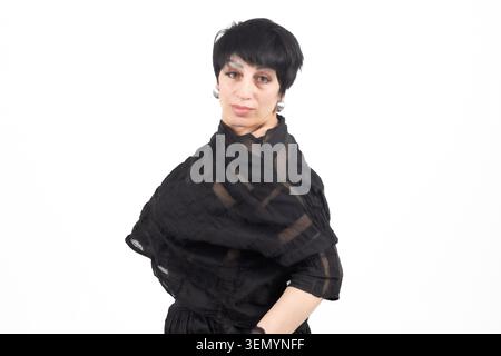 Modèle féminin confiant mature posant élégamment sur fond blanc clair Banque D'Images