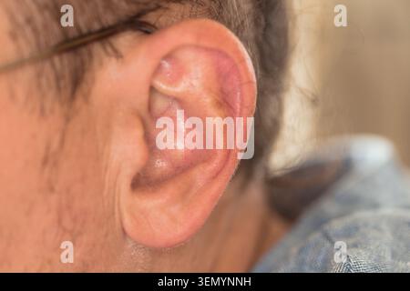 Photographie rapprochée de l'oreille d'un jeune enfant, montrant une vue détaillée de la structure de l'oreille externe. La peau est lisse et légère dans le ton, avec un léger Banque D'Images